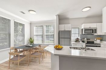 A modern kitchen with a dining table and chairs at Sweetgrass Landing, Mount Pleasant, SC